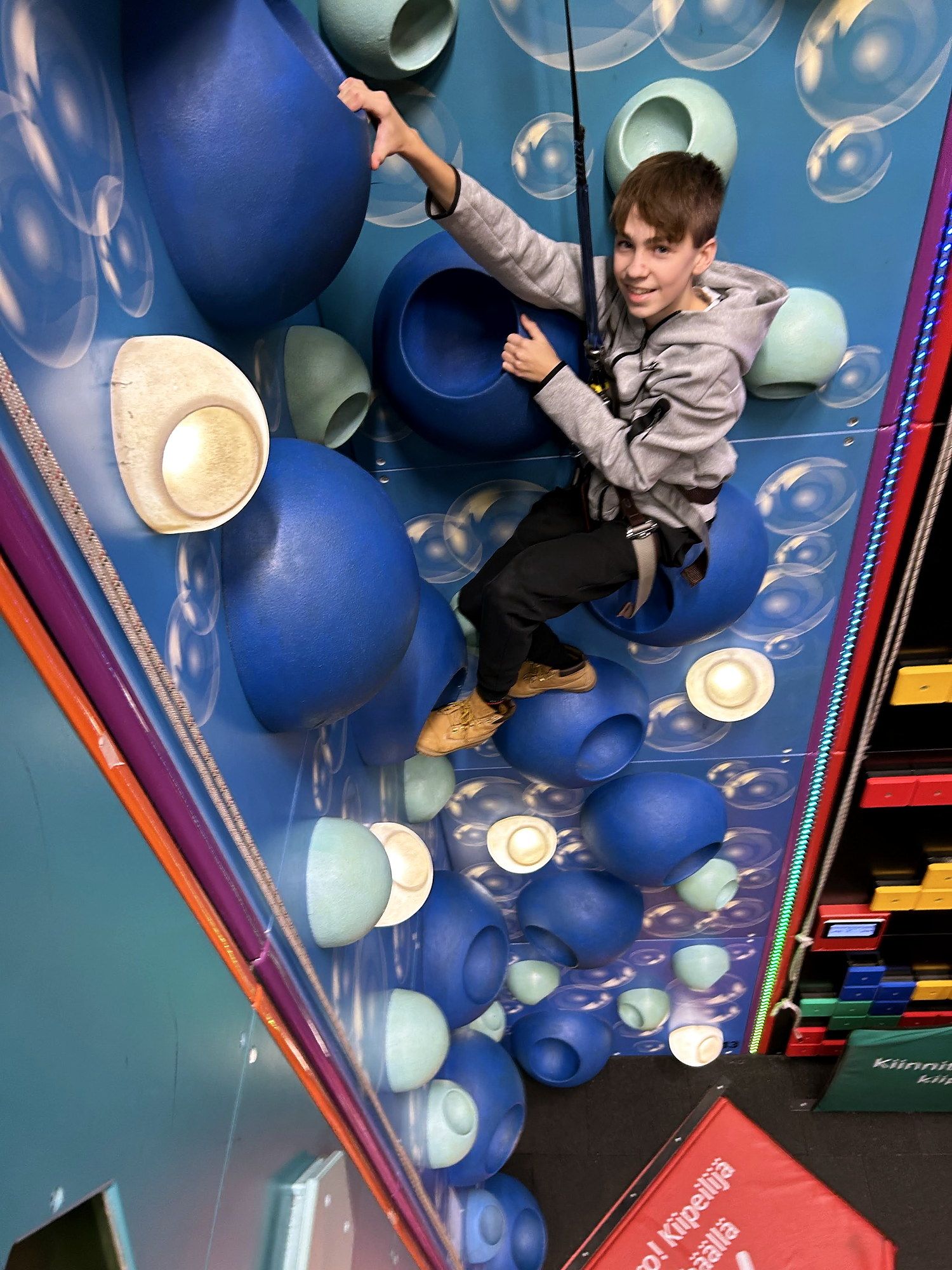 A boy climbing a blue bubble-pattern wall