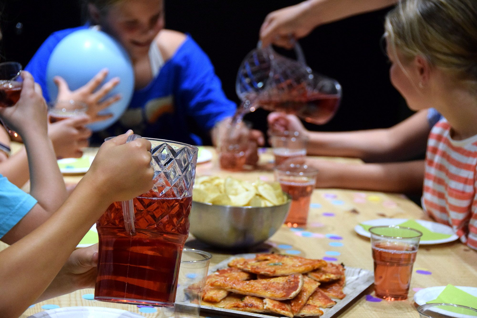Party guests with juice and treats at the table