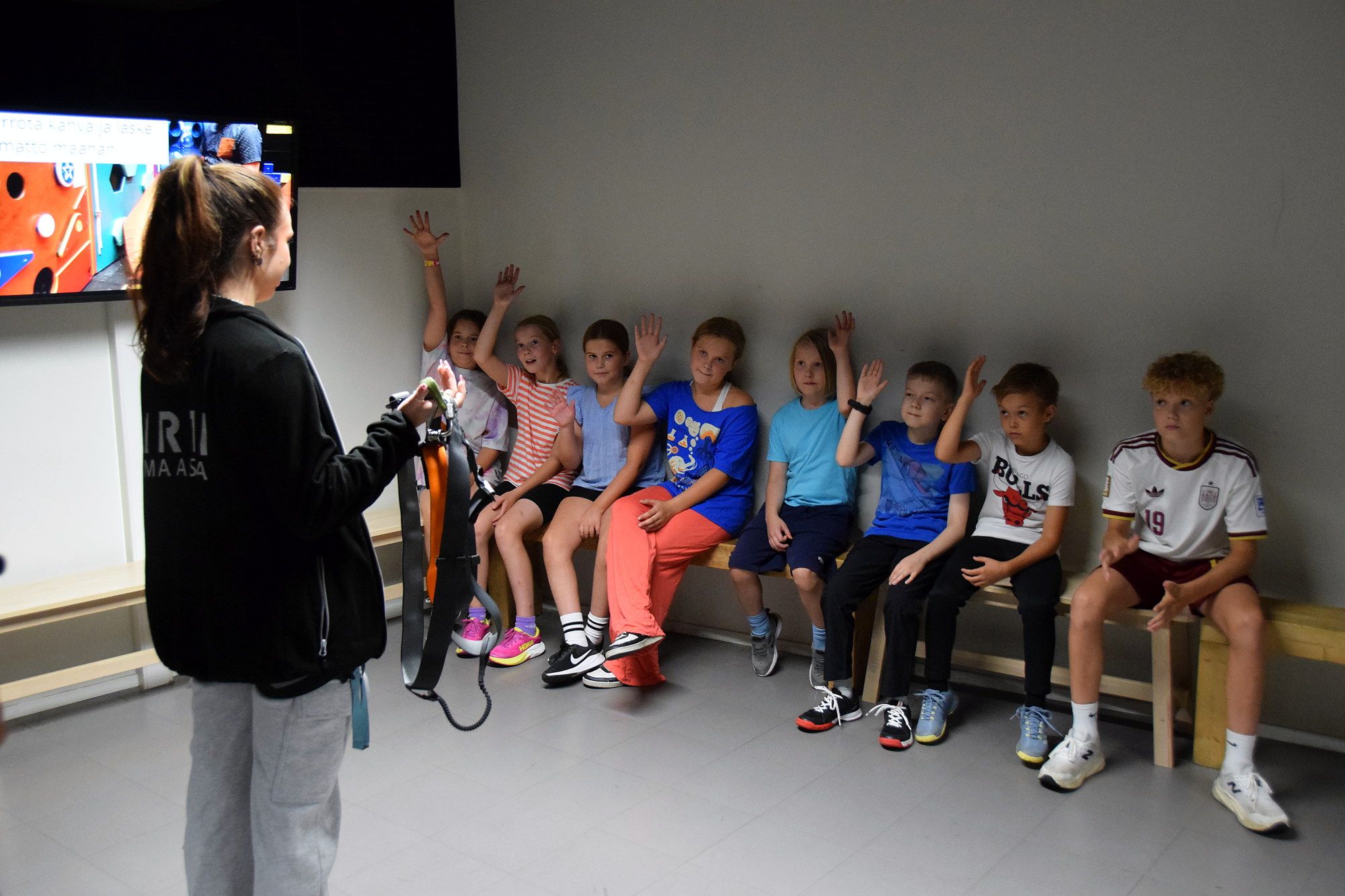 A staff member briefs a group of children before they climb
