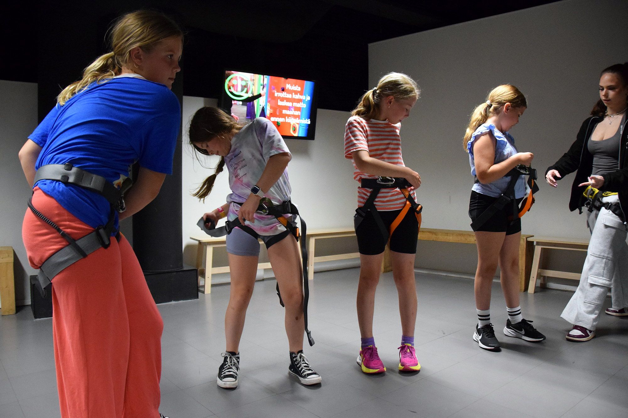 Children putting on climbing harnesses together before climbing
